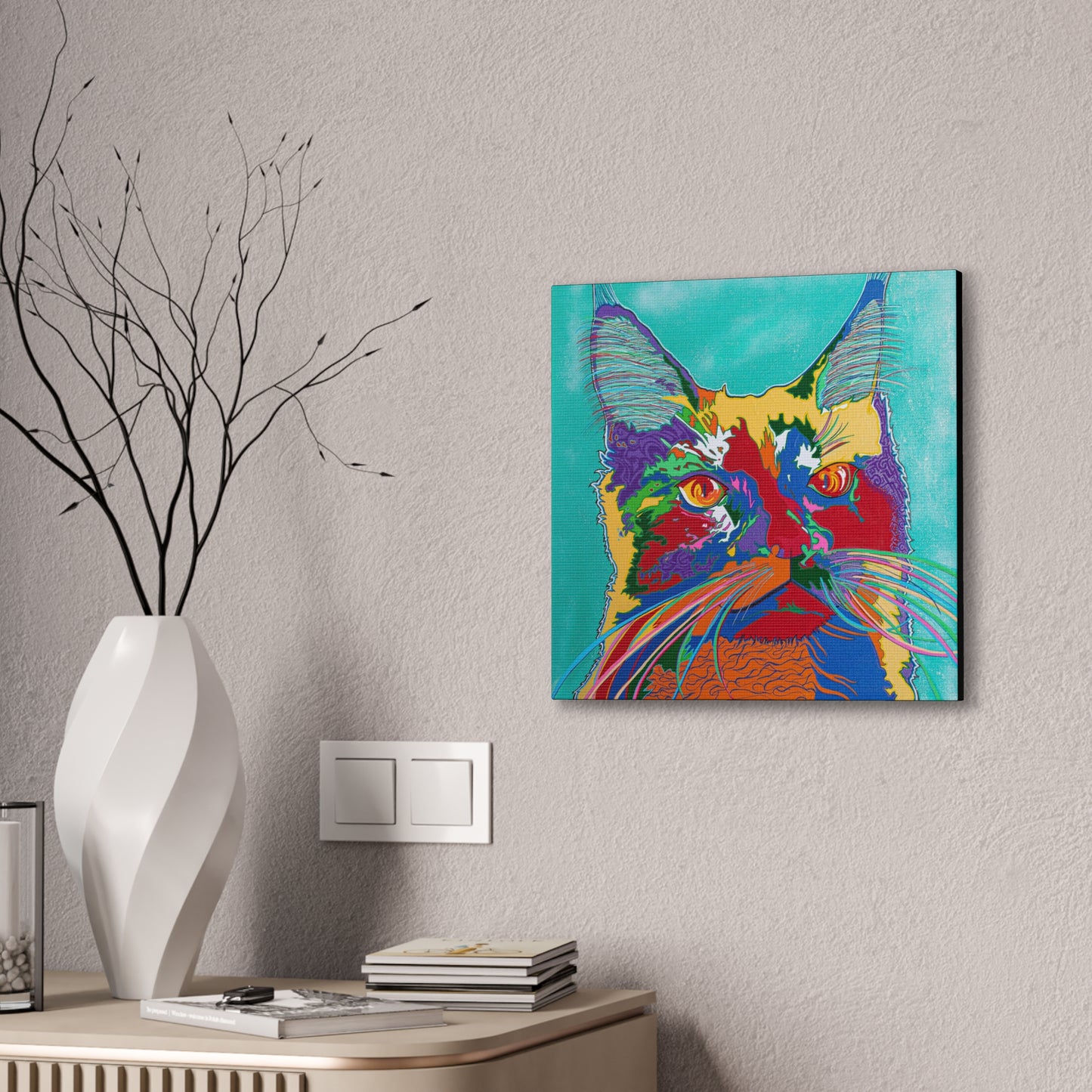 A vibrant pop art style cat portrait on a canvas gallery wrap hangs on a wall.