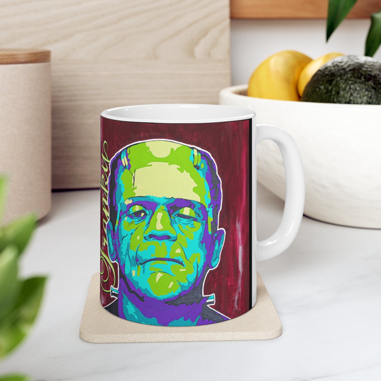 A white ceramic mug with a colorful pop art illustration of Frankenstein's monster.
