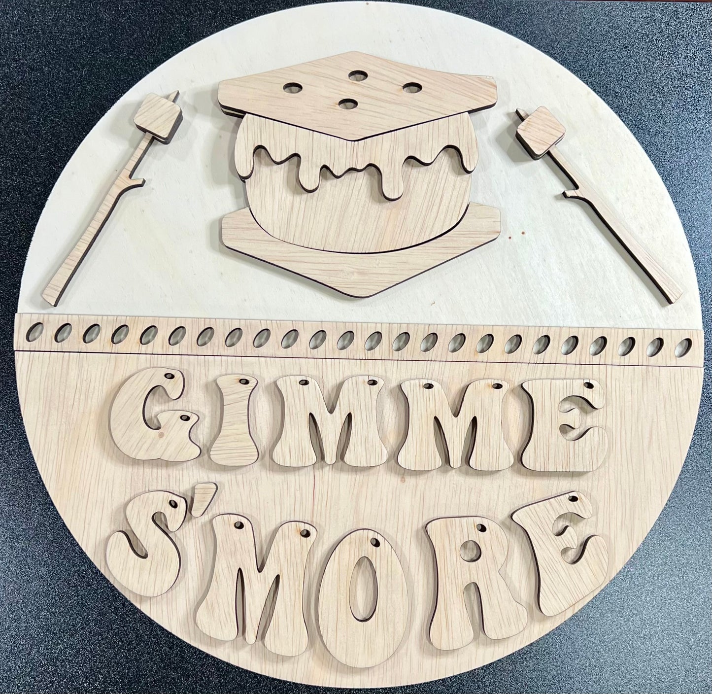Unpainted wooden sign with "Gimme S'more" text and s'mores-themed cutouts.