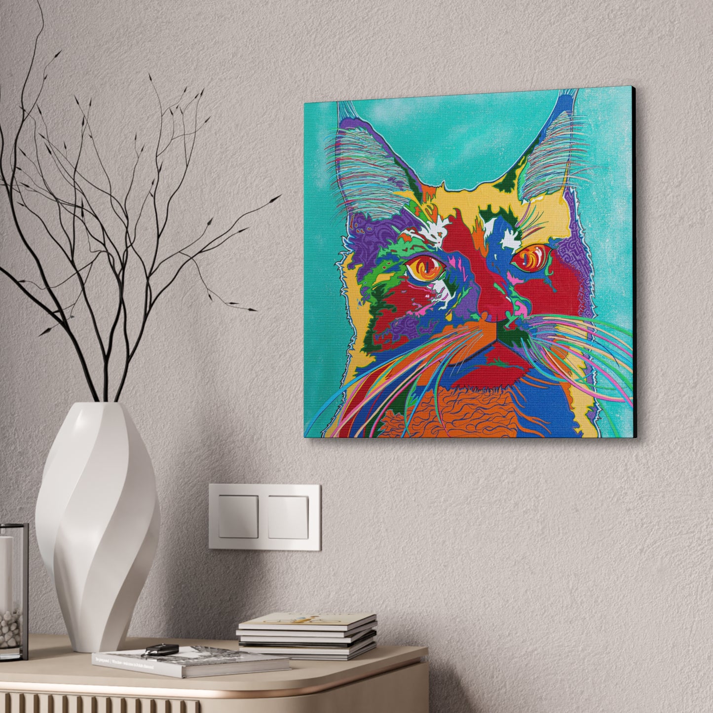 A vibrant, pop-art style canvas print of a cat's face hangs on a textured wall.