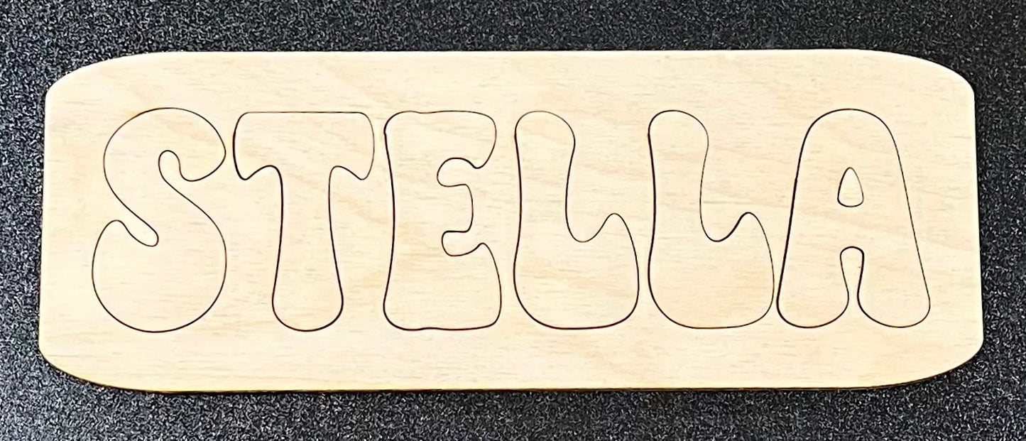 A wooden name puzzle spelling "STELLA" with rounded edges.