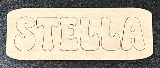 A wooden name puzzle spelling "STELLA" with rounded edges.