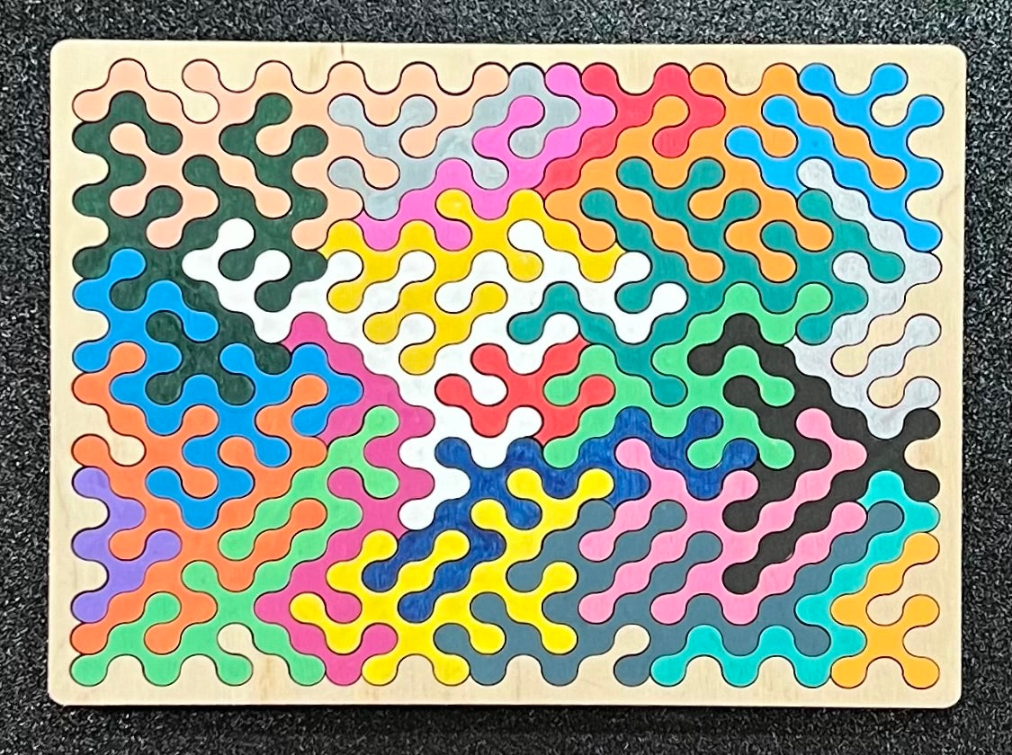 A colorful, wavy-edged wooden puzzle is fully assembled on a dark background.
