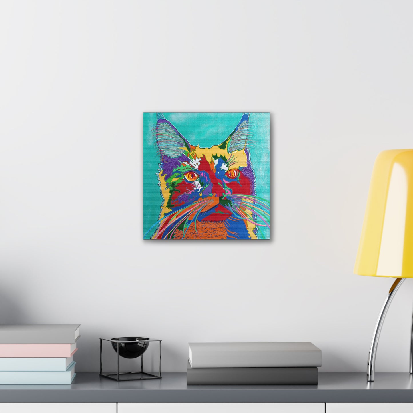 A colorful pop art style cat portrait on a canvas gallery wrap hangs on a white wall.