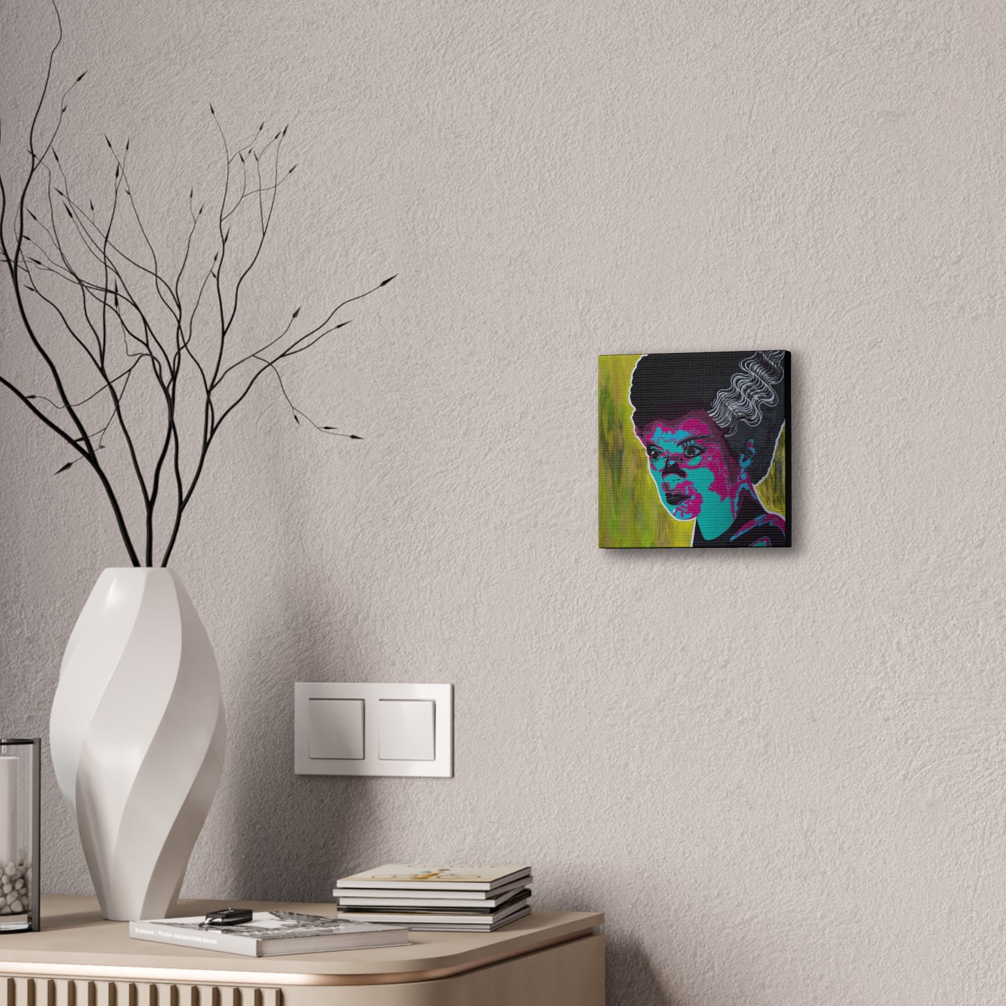 A canvas print of Franky's Bride, a pop art style portrait, hangs on a textured wall.