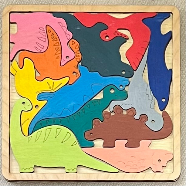 A square wooden puzzle with colorful dinosaur-shaped pieces.