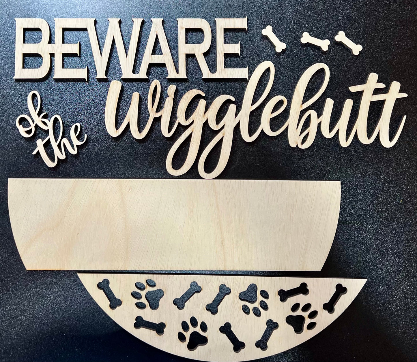 Unpainted wood sign with "Beware of the Wigglebutt" text and dog-themed cutouts.