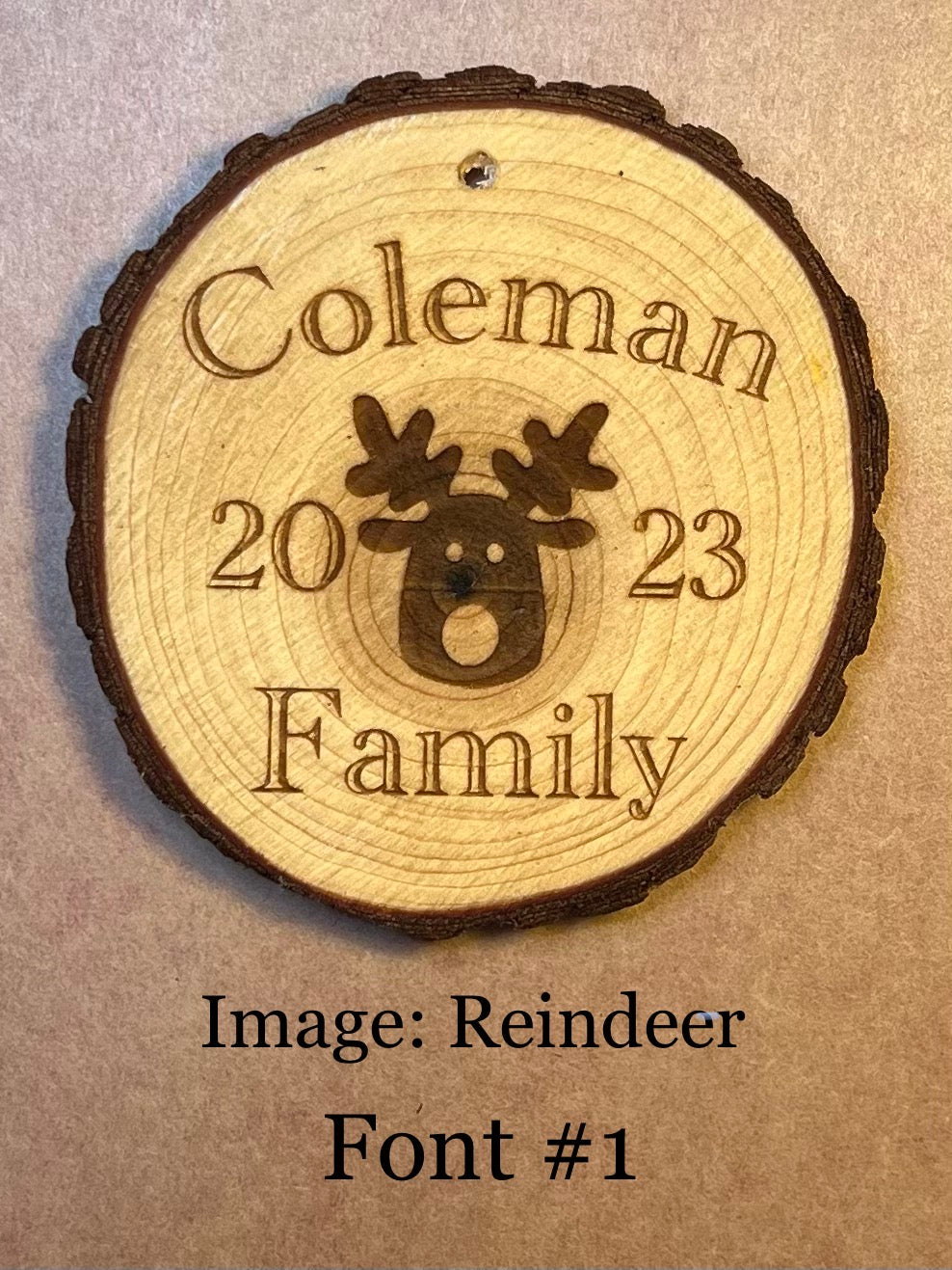 Personalized log wood round ornament engraved with "Coleman 2023 Family" and a reindeer.
