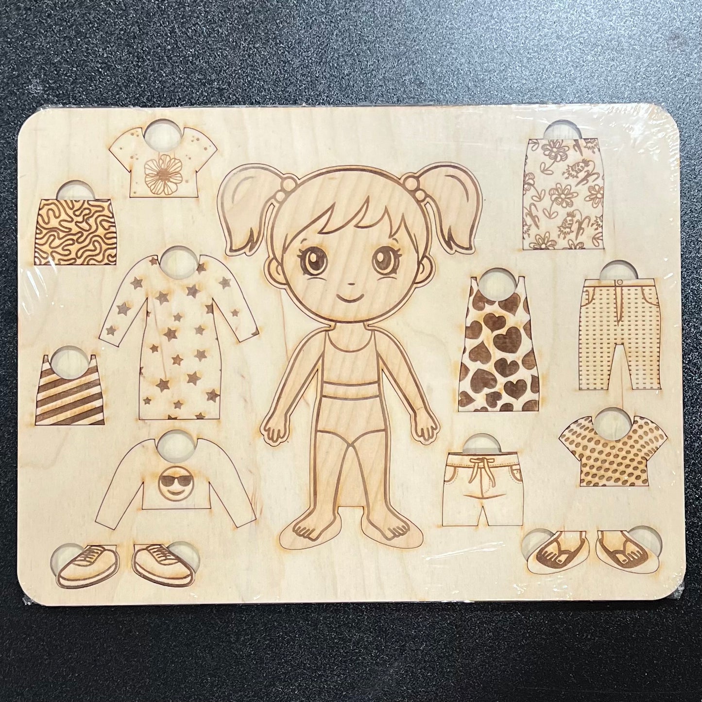 A wooden dress-up puzzle features a girl in a swimsuit and various clothing pieces.