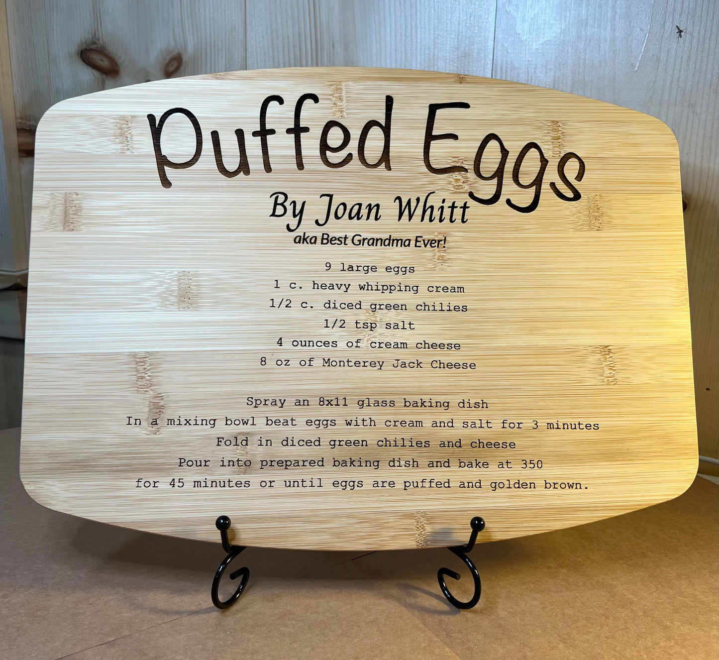 Recipe engraved bamboo board with a black display stand.