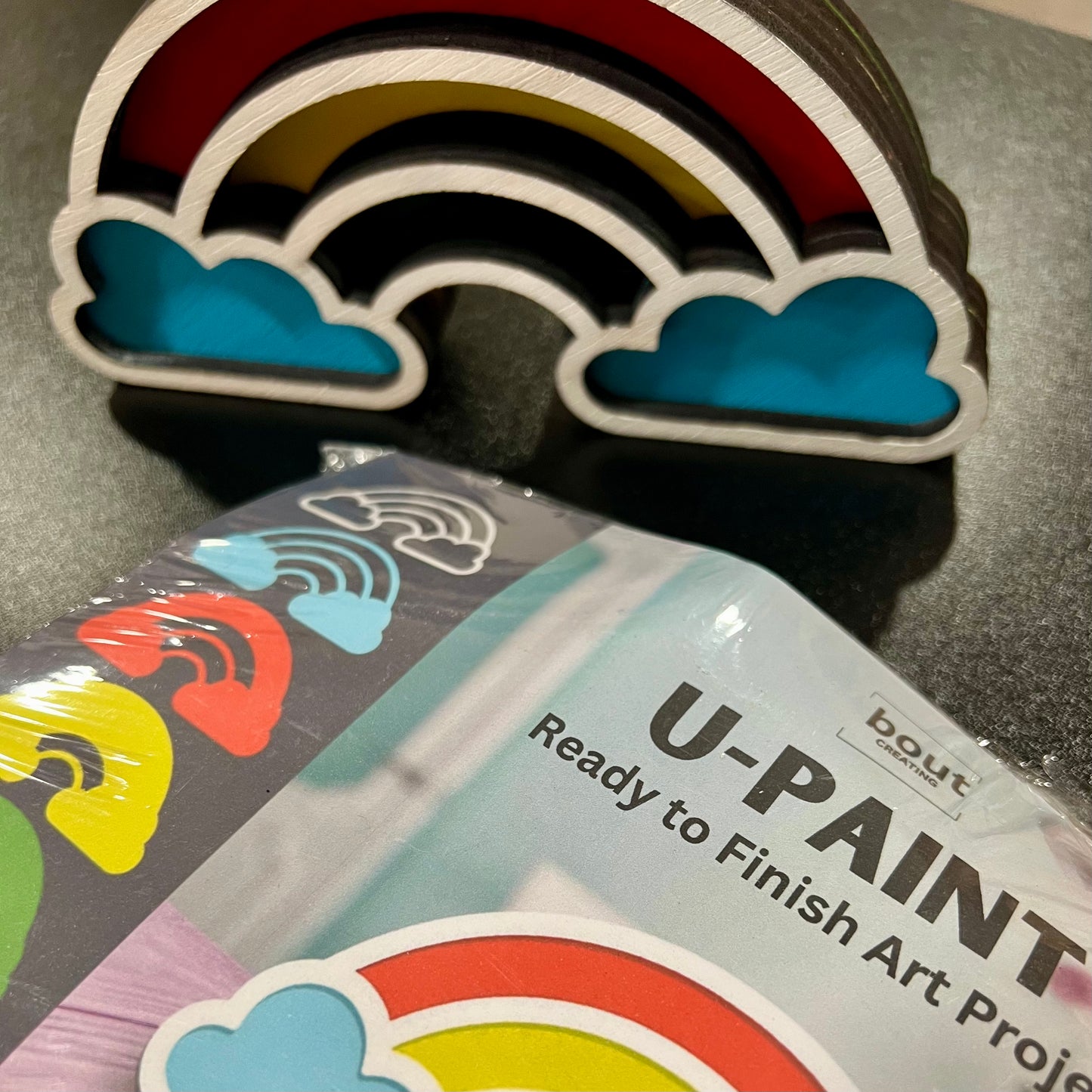 A stacked layered rainbow craft kit with a finished rainbow and packaging.