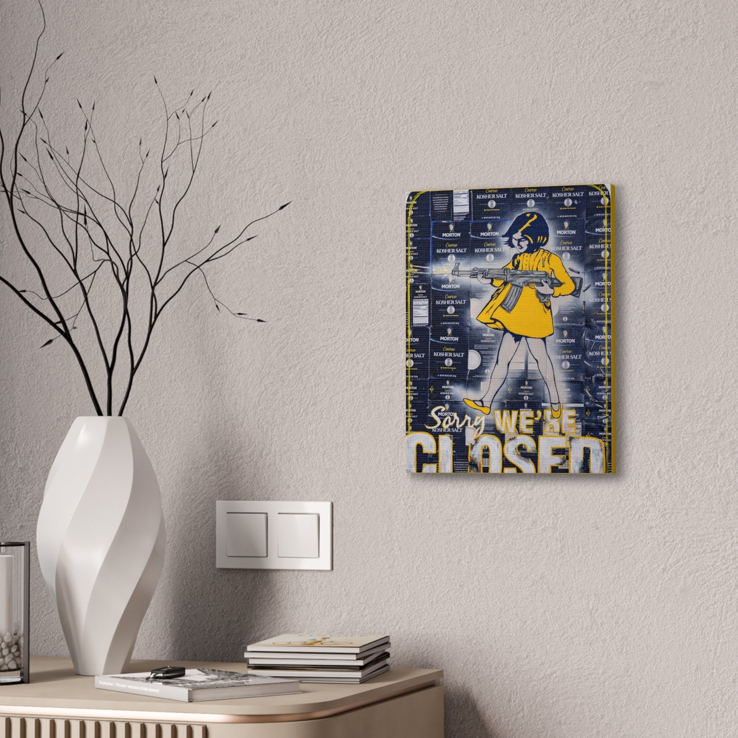 A canvas gallery wrap featuring a woman in yellow holding a rifle, with "Sorry, We're Closed" text.