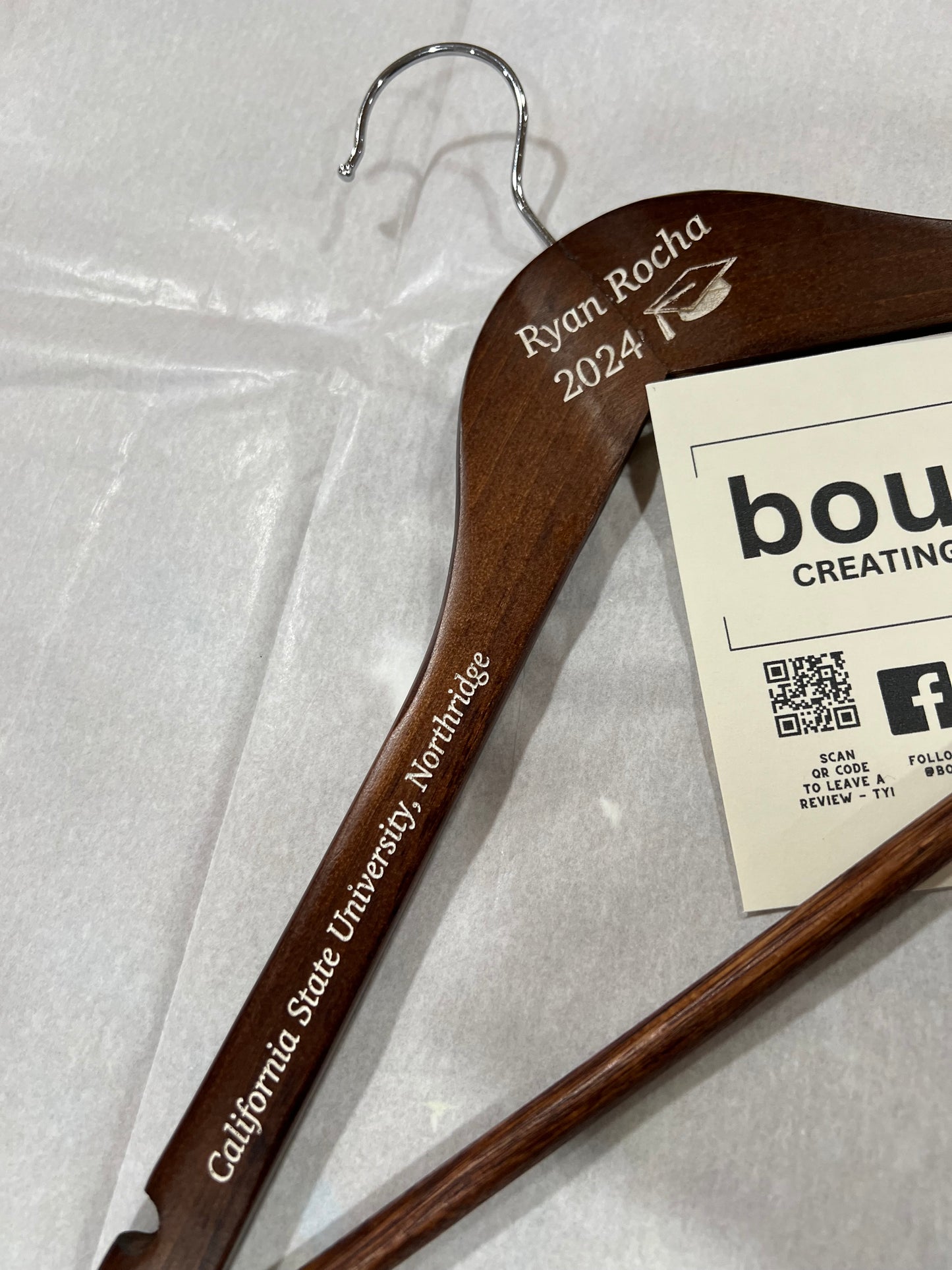 Engraved wooden hanger with "Ryan Rocha 2024" and "California State University, Northridge" text.